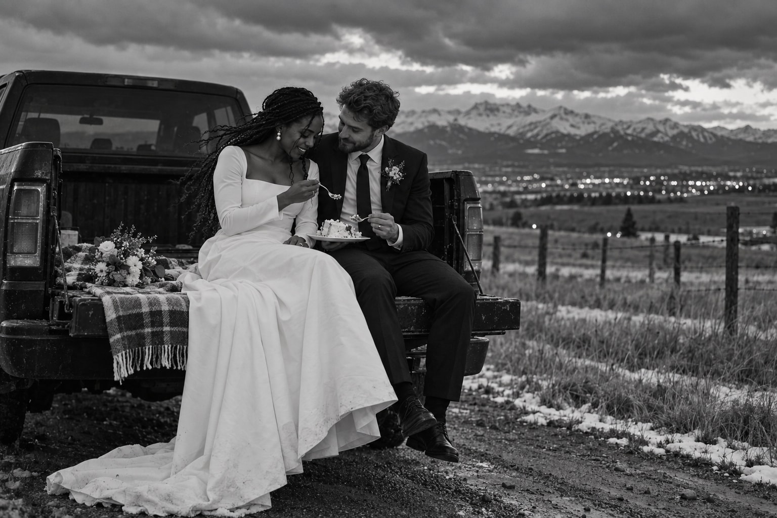 Newlyweds sharing cake beside a pickup in the Calgary foothills