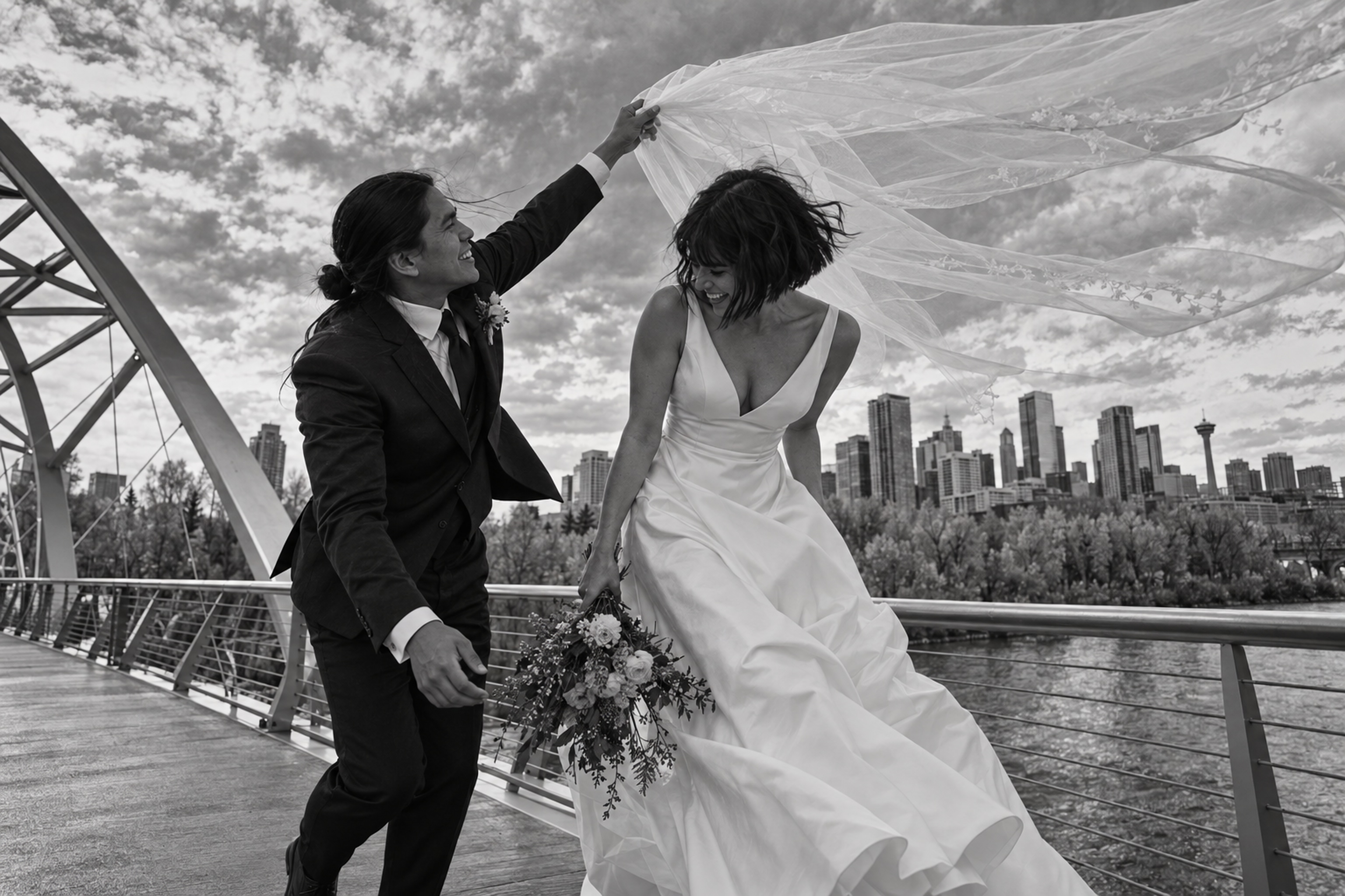 Newlyweds crossing an East Village bridge beneath the Calgary skyline