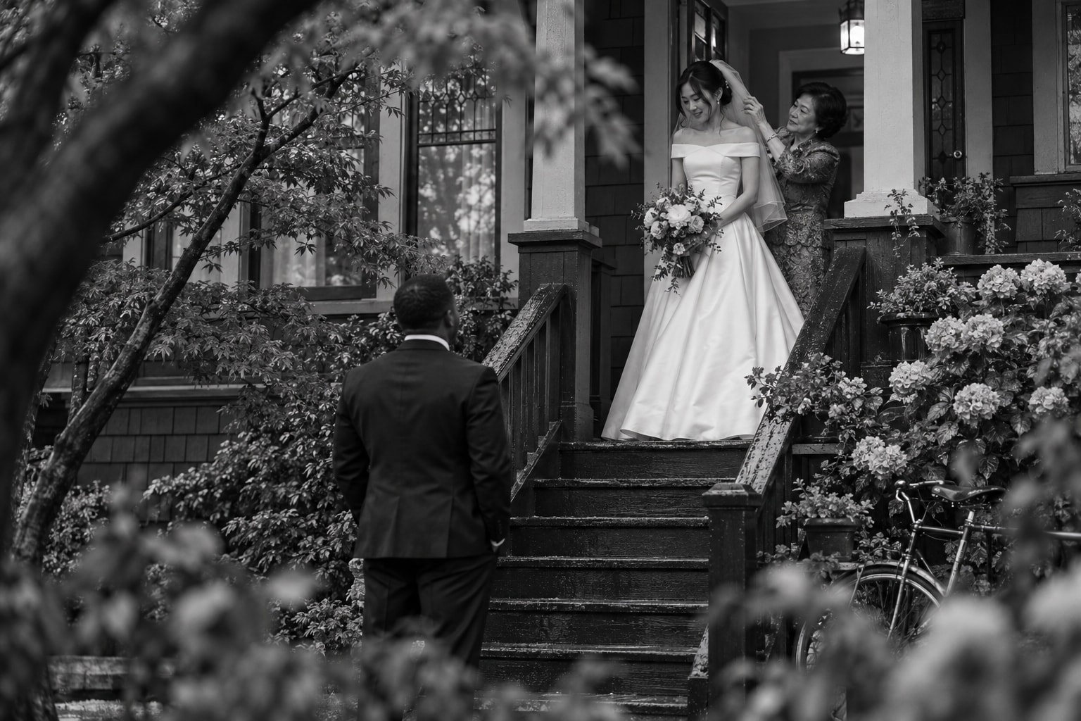 A newly married couple embraced by a grandmother on a Fairfield porch