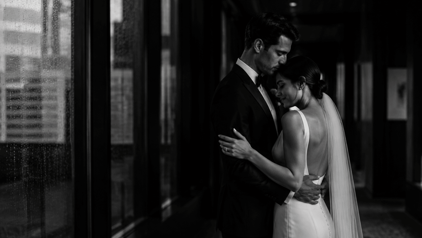Newlyweds sharing a quiet embrace in a cinematic hotel corridor