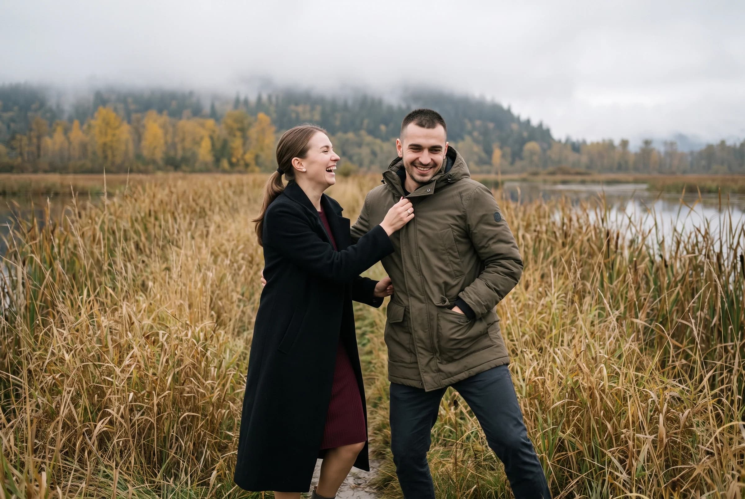 Couple laughing together on a dyke trail through tawny marsh grass at Minnekhada Regional Park